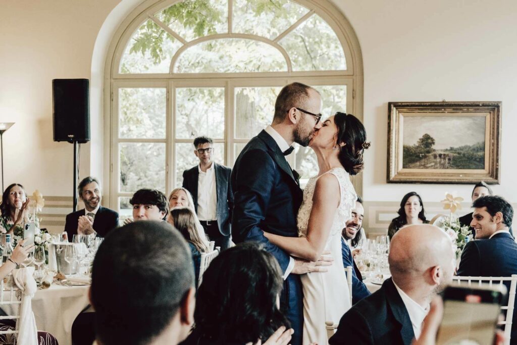 sposi si baciano nella sala ricevimento